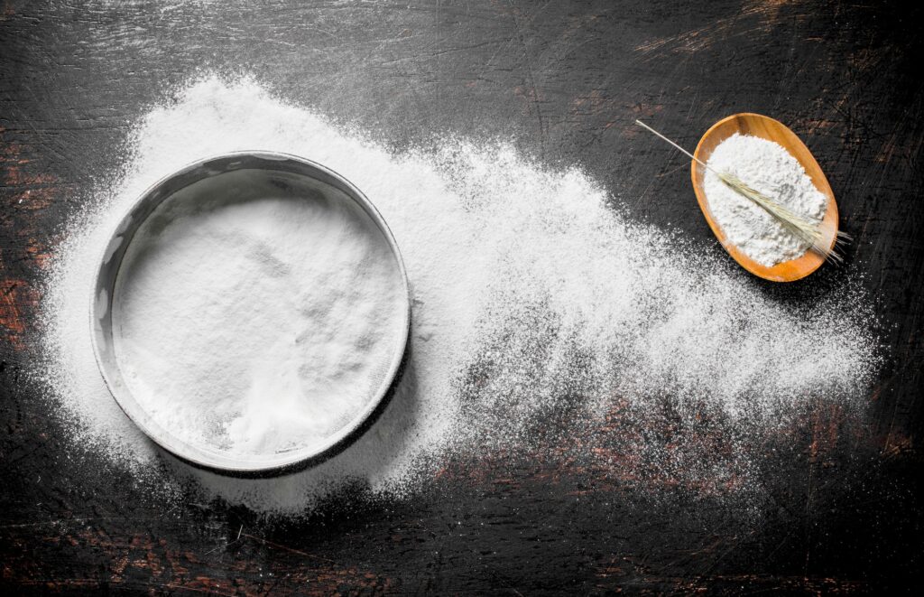 Flour in a bowl with a sieve.